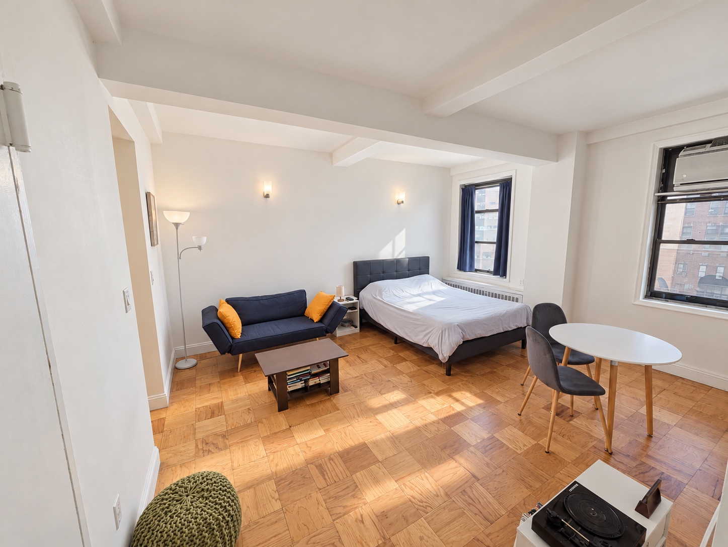 Wide daytime view of the studio, dining area, and windows at 132 East 45th Street